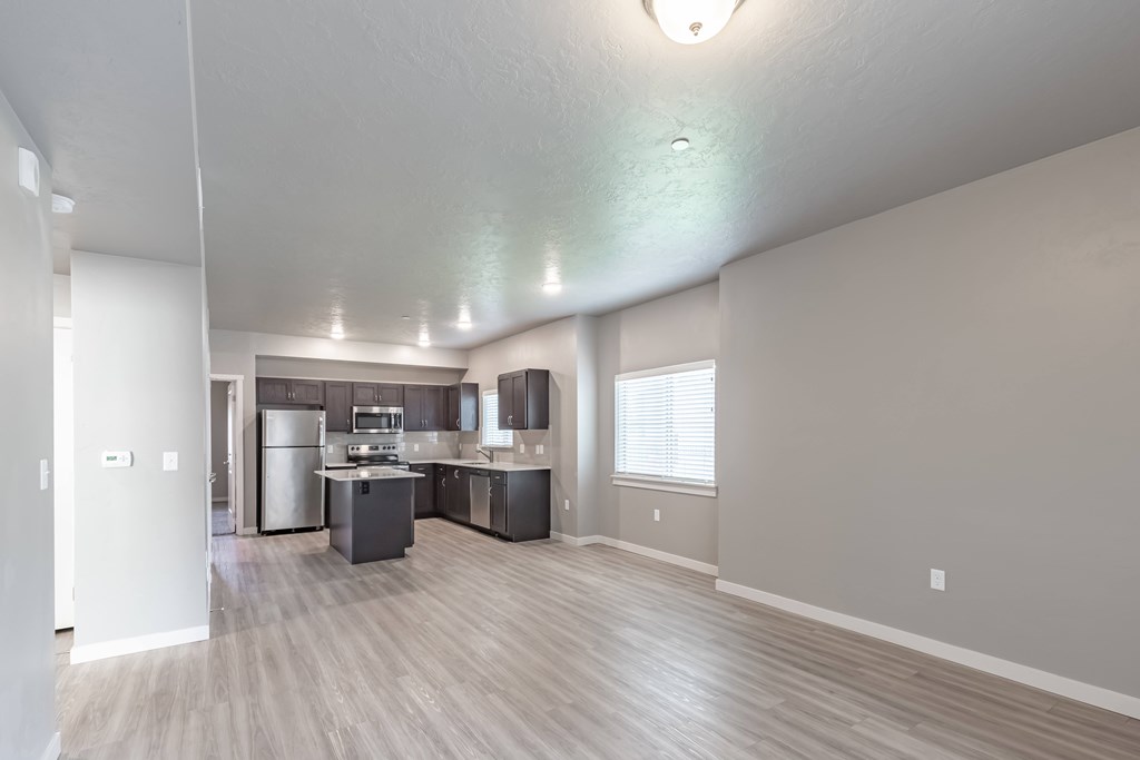 A spacious kitchen with a refrigerator, sink, and stove. at Harper Ridge Apartments, Meridian, Idaho