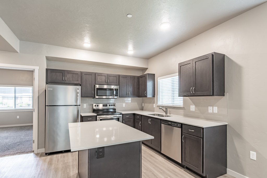 A modern kitchen with stainless steel appliances and dark wood cabinets. at Harper Ridge Apartments, Meridian, ID, 83642