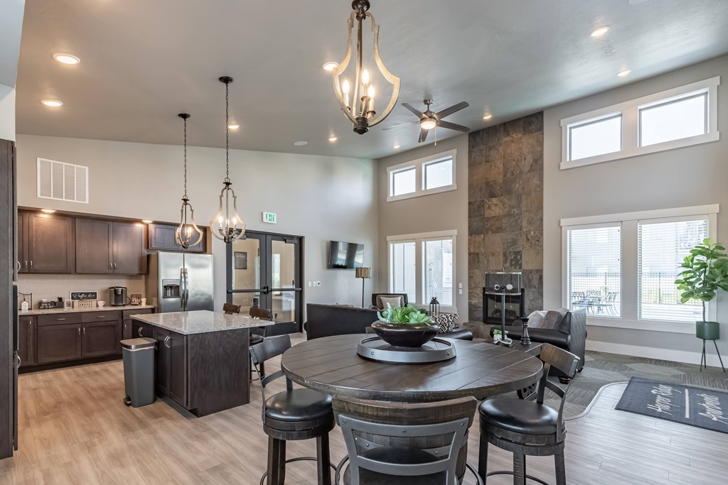 A modern kitchen with a dining table and chairs. at Harper Ridge Apartments, Meridian