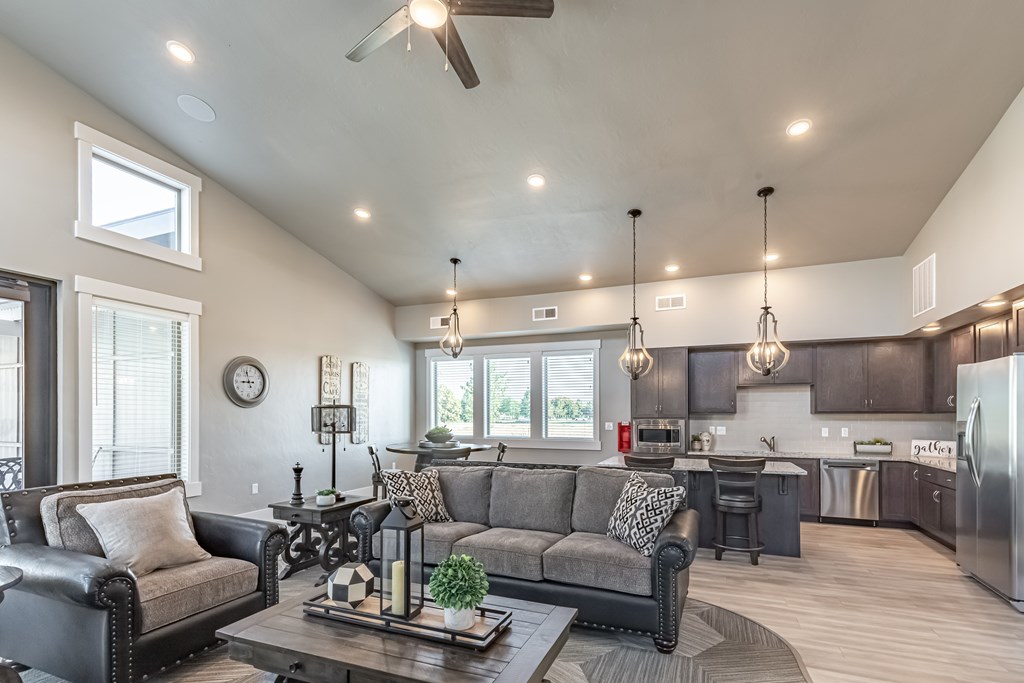 A modern living room with a grey couch and a wooden coffee table. at Harper Ridge Apartments, Meridian, ID