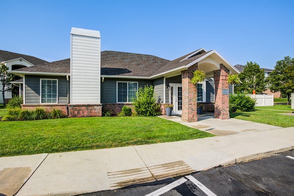 a house with a lawn and a sidewalk in front of it