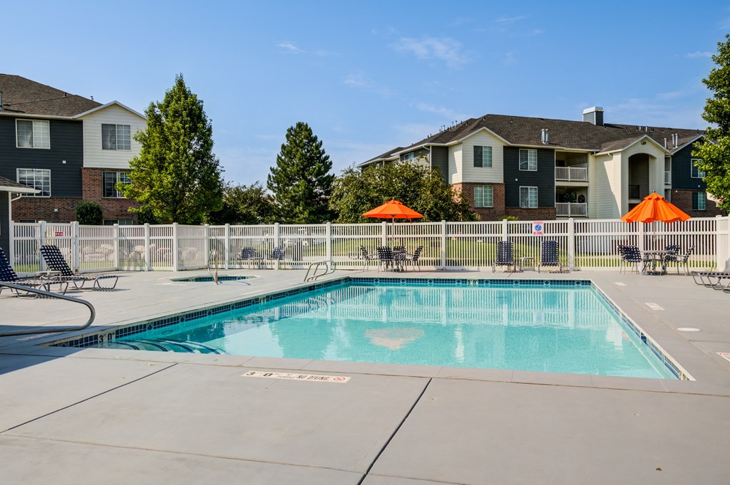 our apartments have a resort style pool with chairs and umbrellas