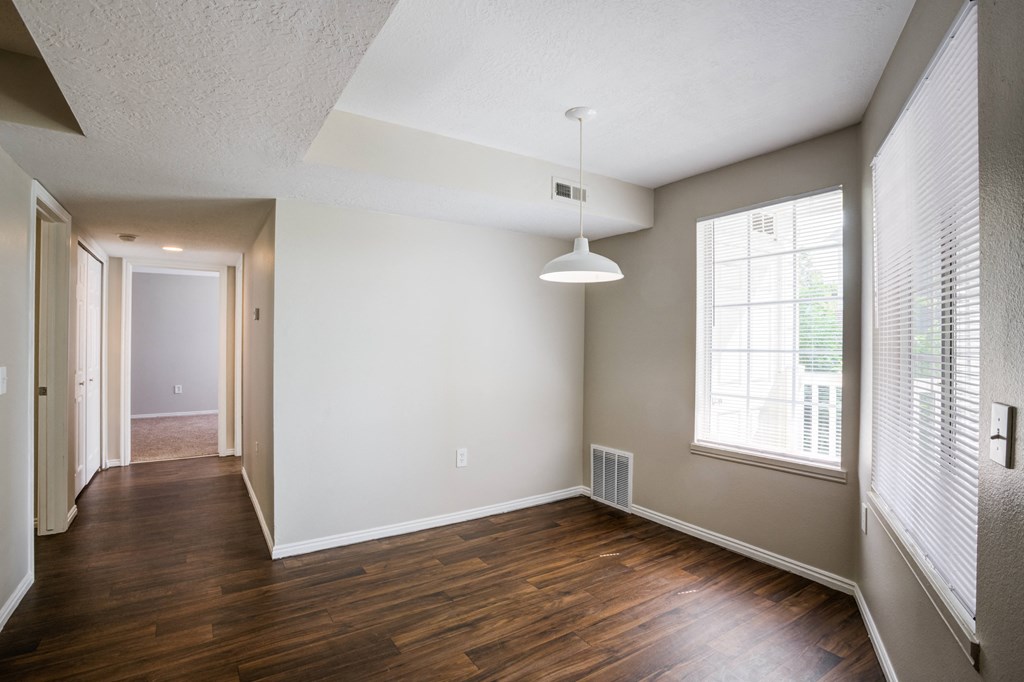 an empty living room with wood flooring and a large window