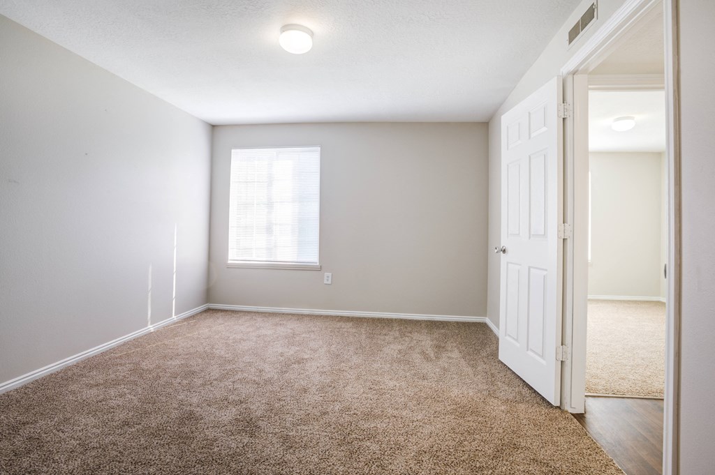 an empty room with a door and a window