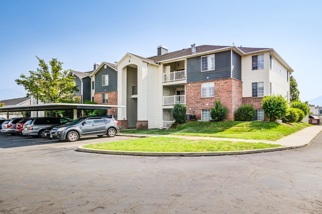 an apartment building with cars parked in a parking lot