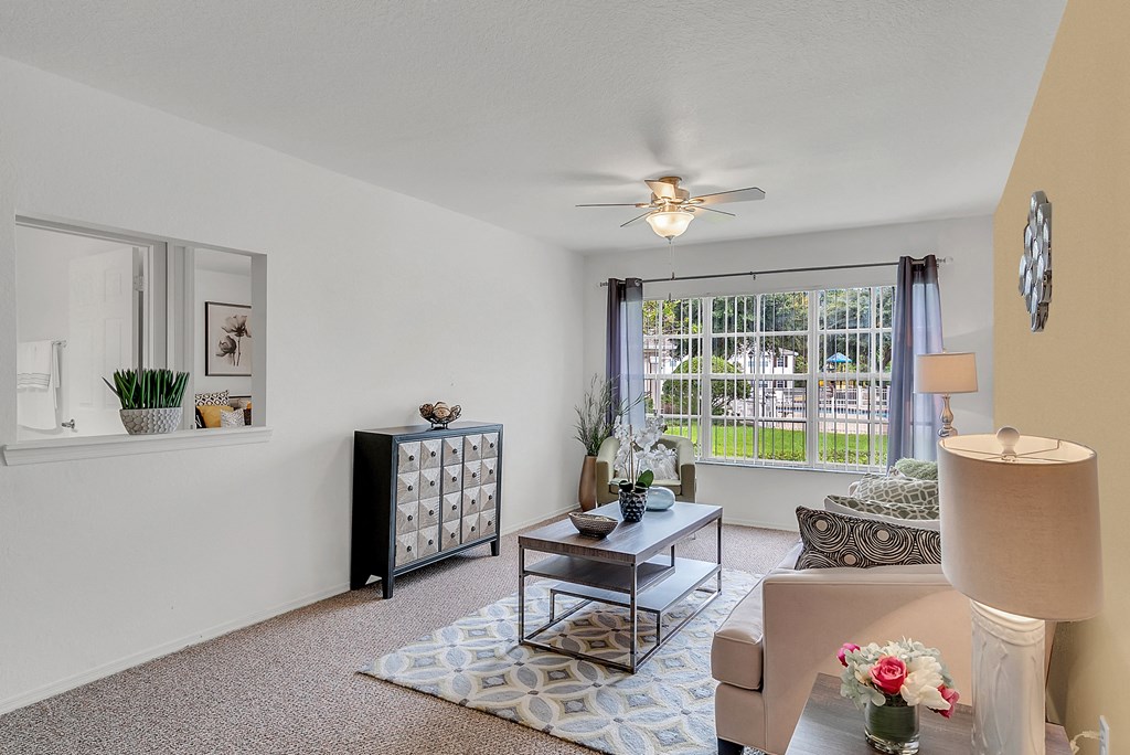an open living room with a ceiling fan and a window