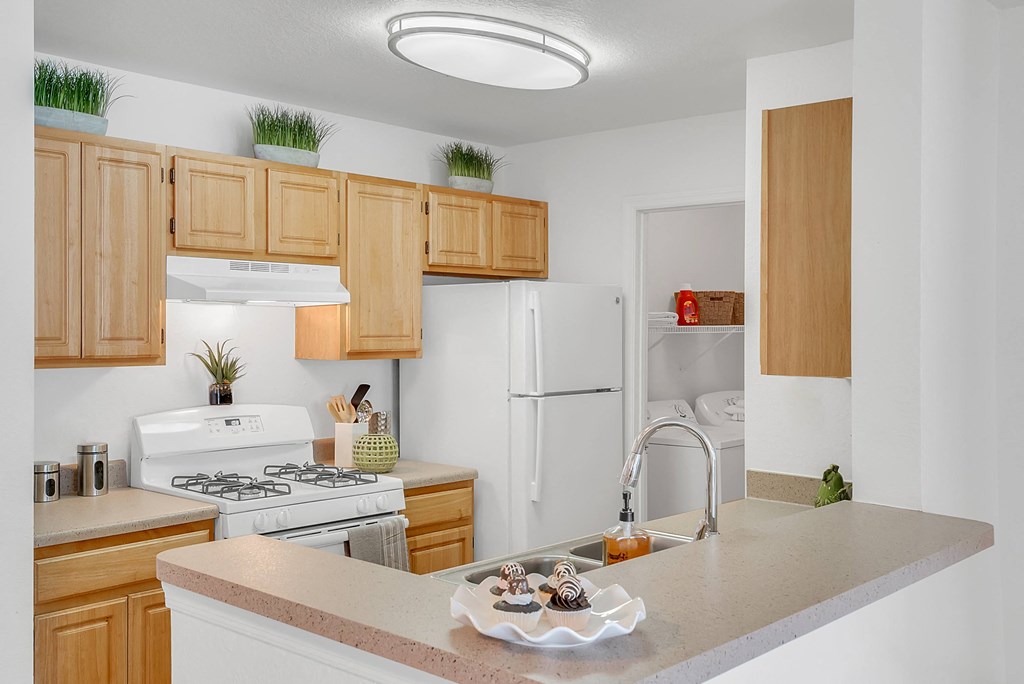 a kitchen with white appliances and wooden cabinets
