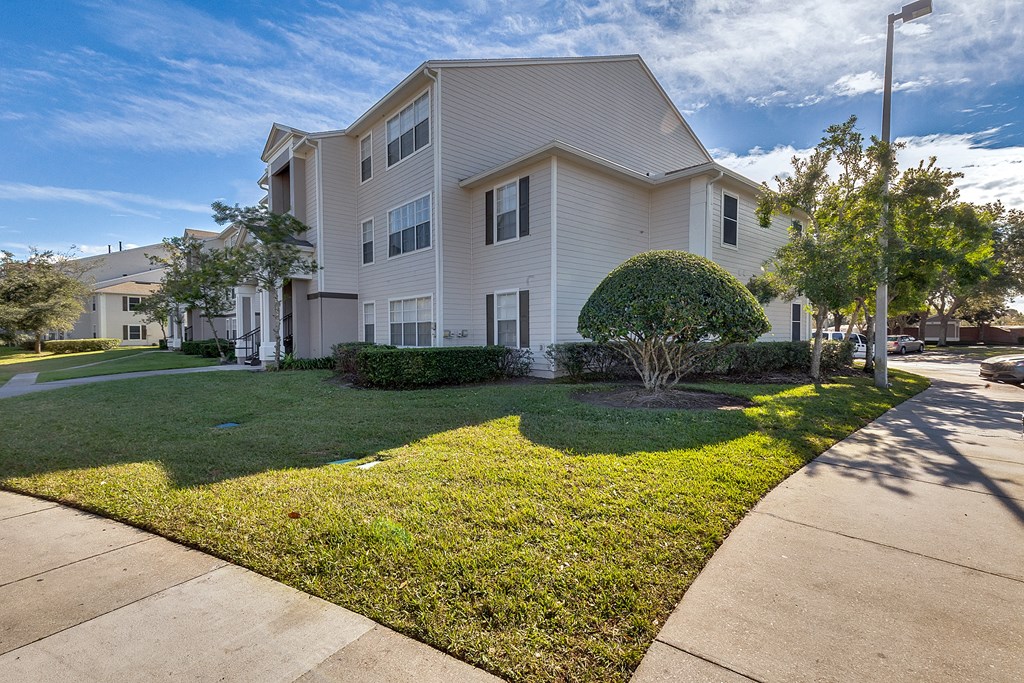 a white house with grass and trees in front of it