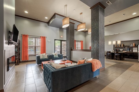 the lobby of a clubhouse with couches and a table at Hurstbourne Estates Apartments, Louisville
