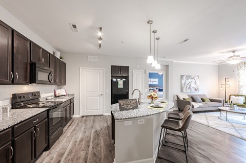 an open kitchen and living room with a large counter top