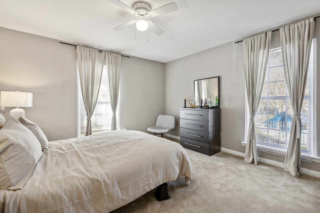 A bedroom with a large bed and a dresser.