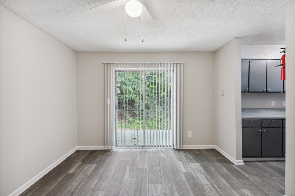a spacious living room with a large window and a sliding glass door