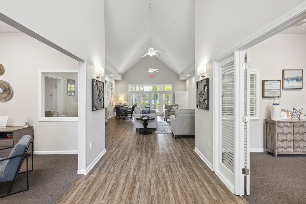 the living room and dining room of a house with white walls and wooden floors
