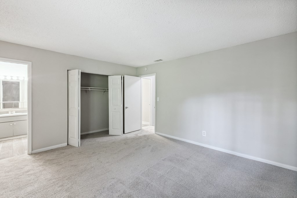 an empty living room with white walls and a closet