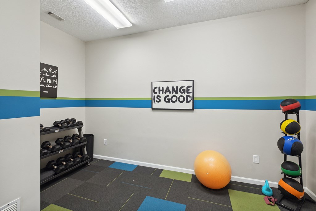 a fitness room with an orange ball and a sign that says change is good
