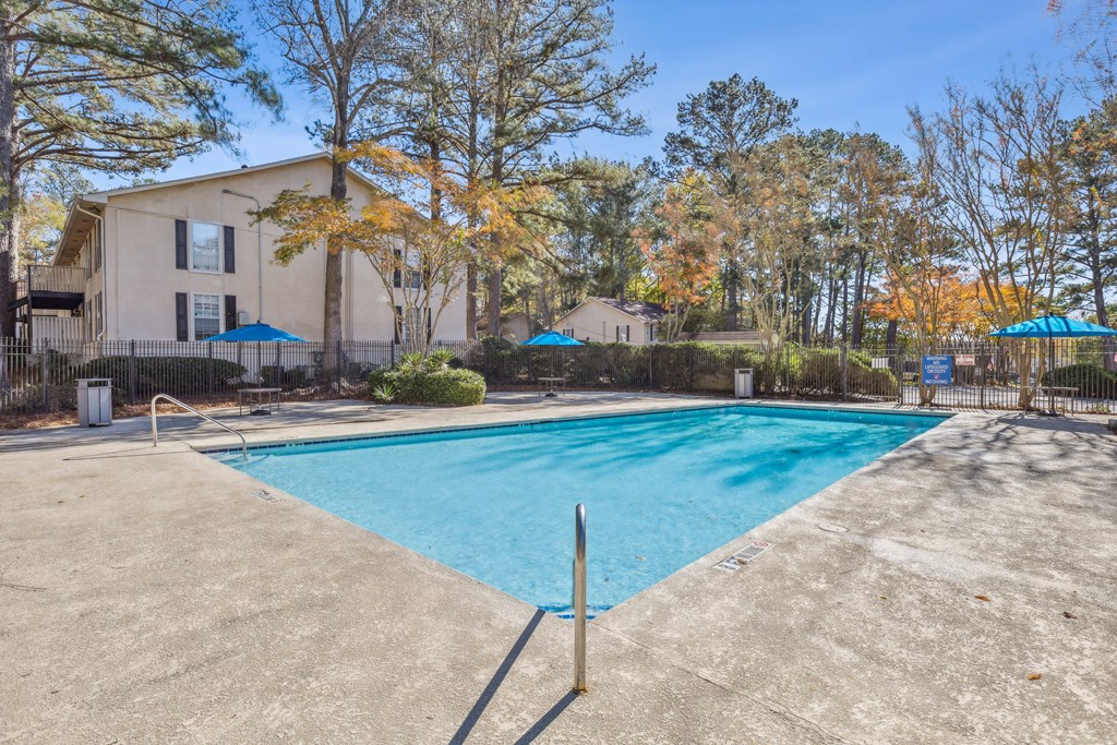 A swimming pool surrounded by a fence and trees.