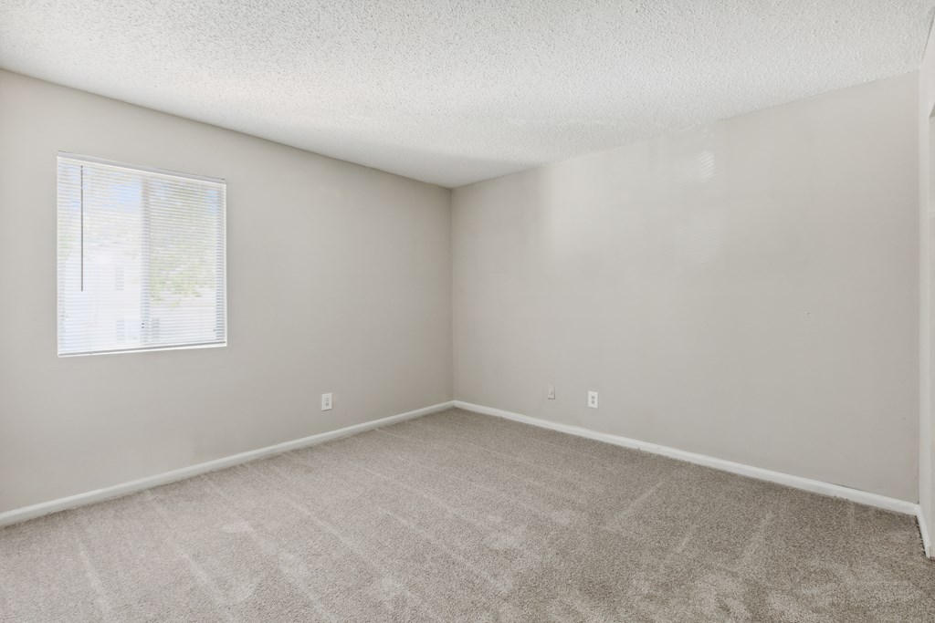 an empty room with carpet and a window
