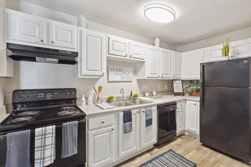 the preserve at ballantyne commons apartment kitchen with black appliances and white cabinets