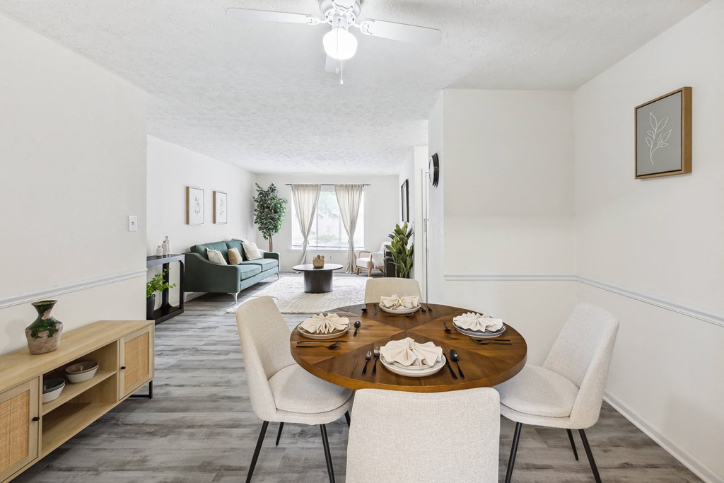 a living room and dining room with a table and chairs