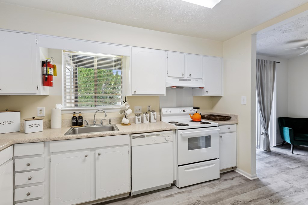 a kitchen with white cabinets and appliances and a sink