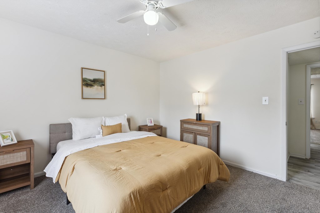 a bedroom with a bed and a ceiling fan