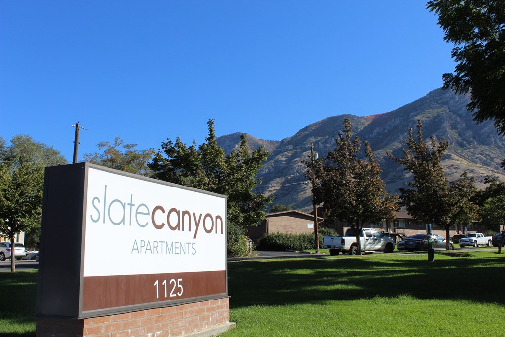 a sign for store canyon apartments with mountains in the background