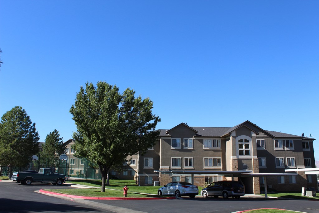 a large apartment building with cars parked in front of it