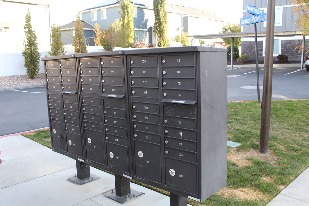 a bunch of mailboxes are on a sidewalk in front of a building