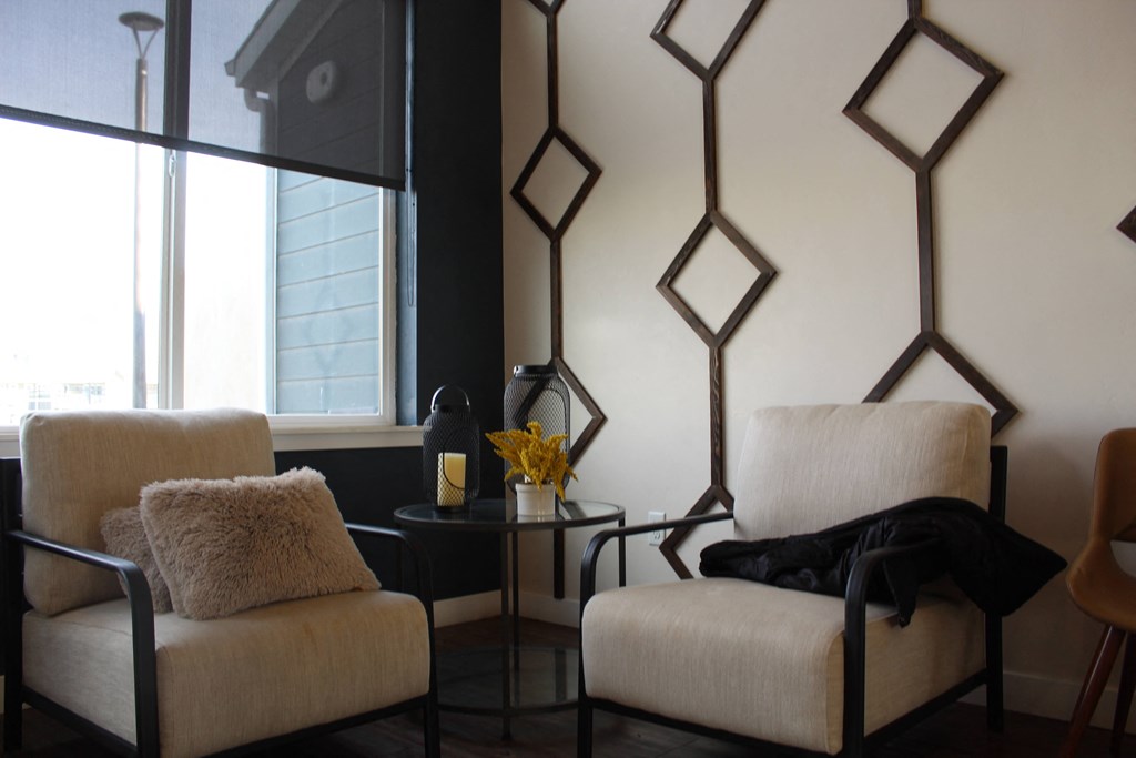 two chairs and a table in a room with a window