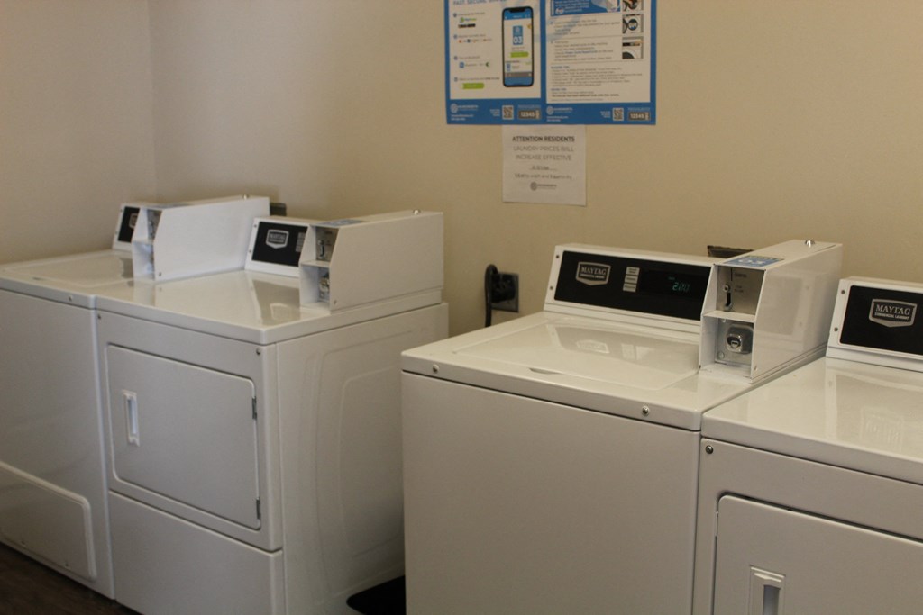 three washers and dryers in a laundry room