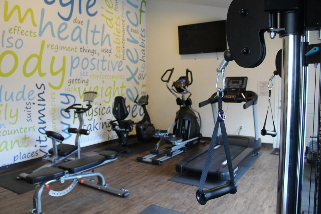 a workout room with weights and a wall with writings on it