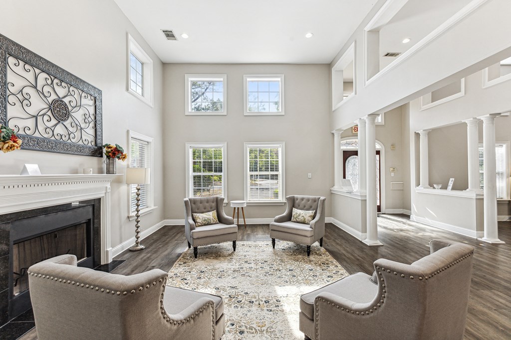 a living room with chairs and a fireplace