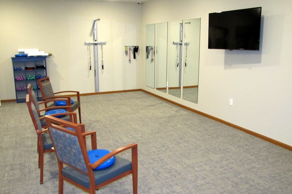 a waiting room with chairs and a television