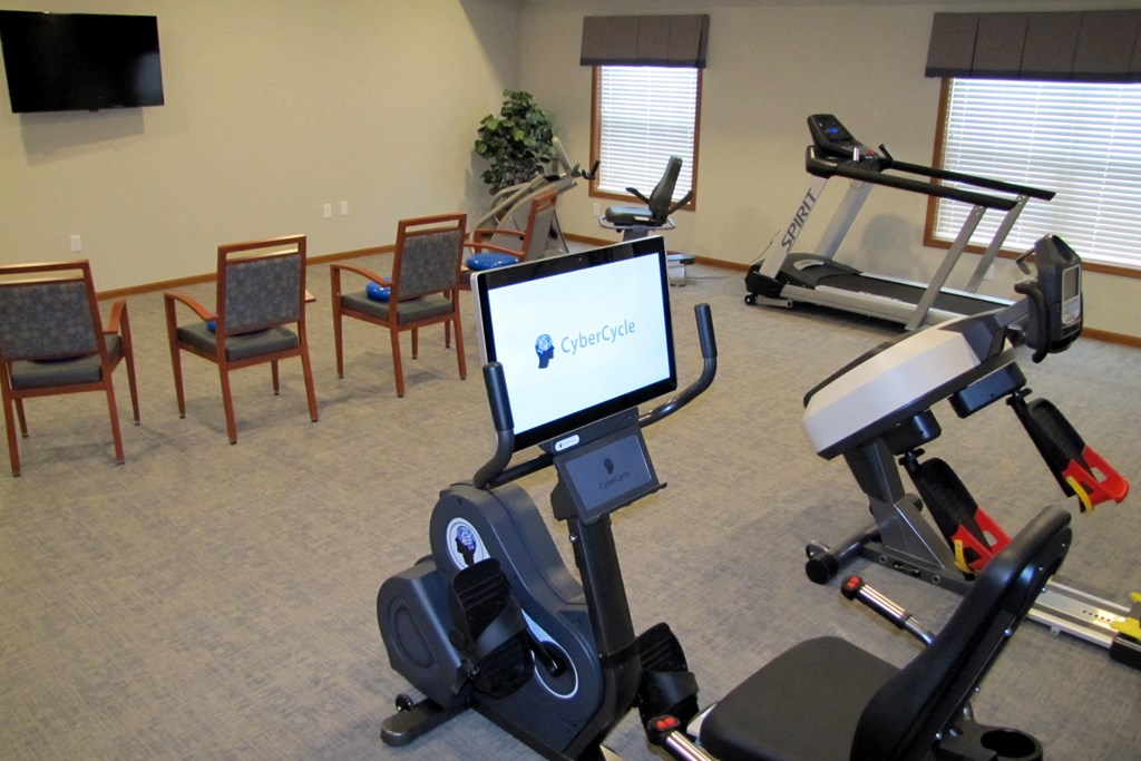 a gym with exercise equipment and a computer on the floor