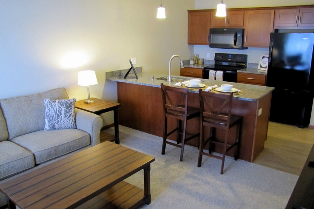 a living room and kitchen with a couch and a table