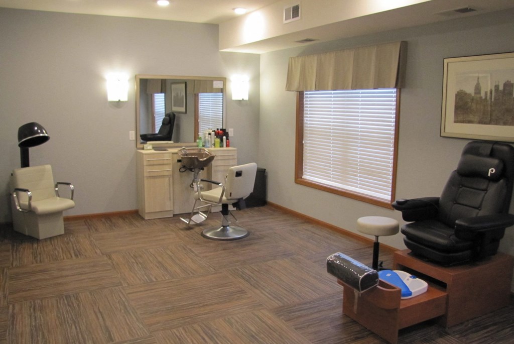 a small office with a chair and a desk with a mirror