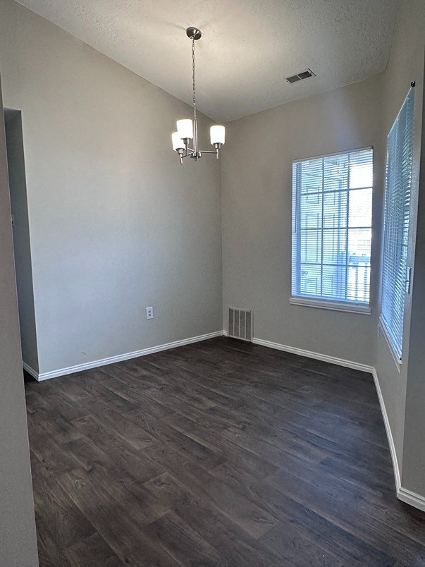 an empty living room with wood floors and a window