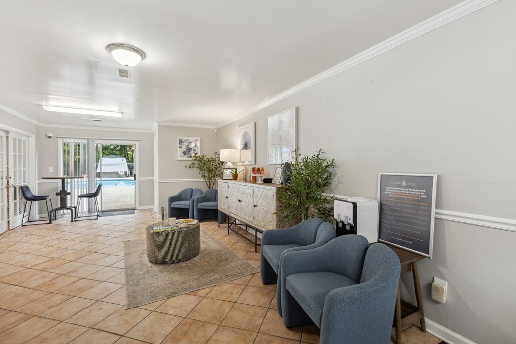 a living room with chairs and a table and a door to a pool
