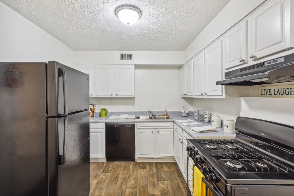 a kitchen with white cabinets and stainless steel appliances and a refrigerator
