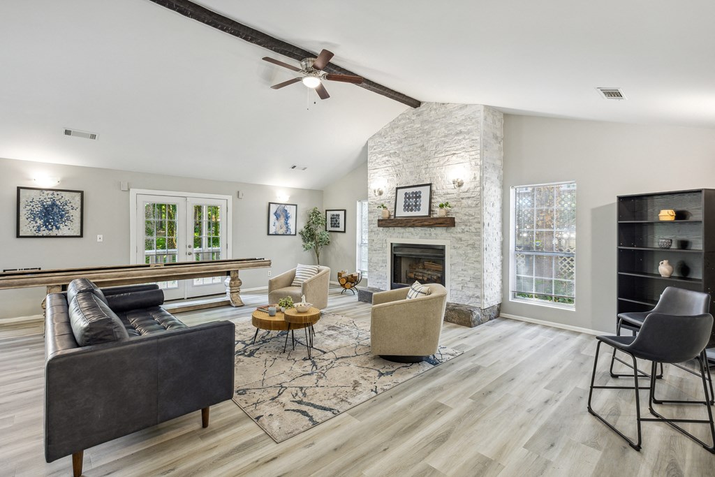 an open living room with a fireplace and a ceiling fan