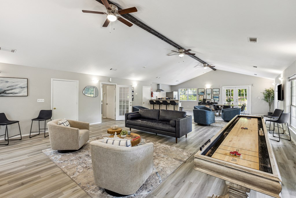 a living room with couches and chairs and a shuffleboard table