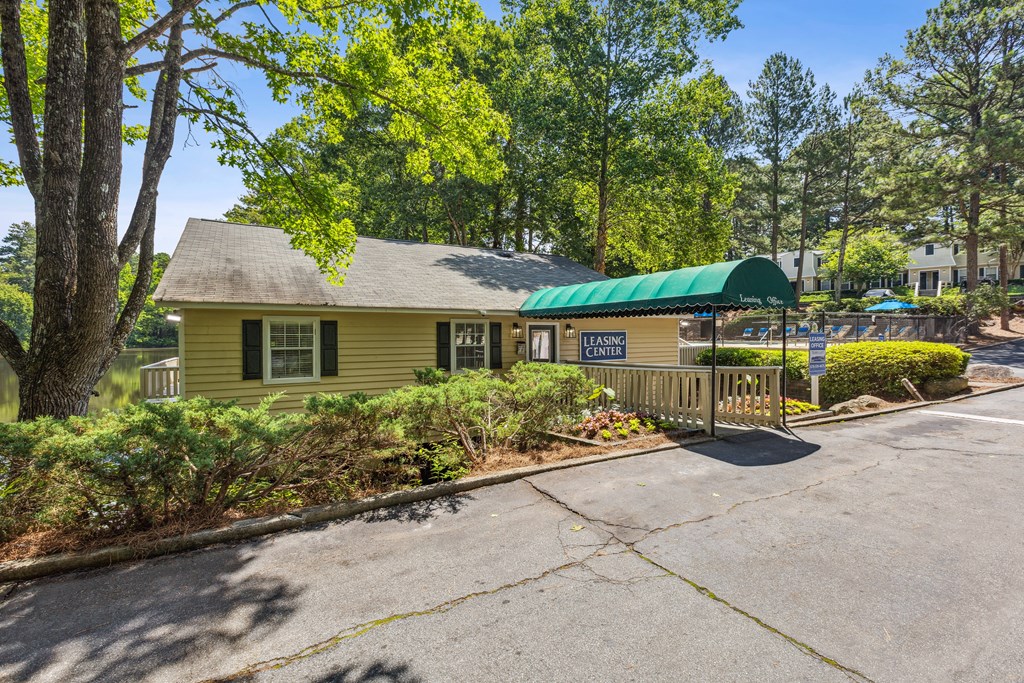 a yellow building with a green roof and a parking lot
