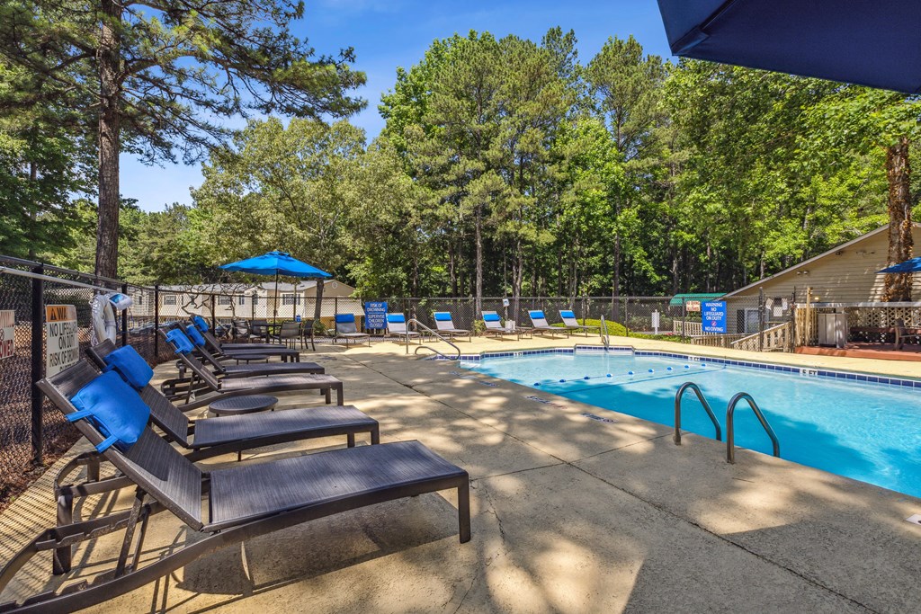 our resort style swimming pool is next to a row of lounge chairs