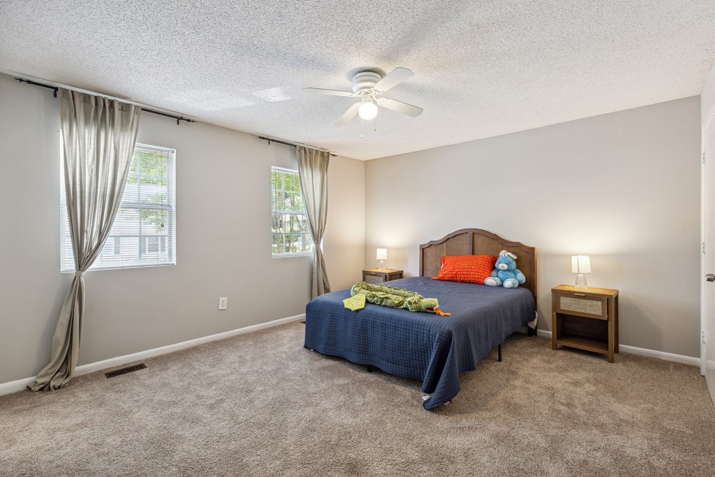 a bedroom with a bed and a ceiling fan