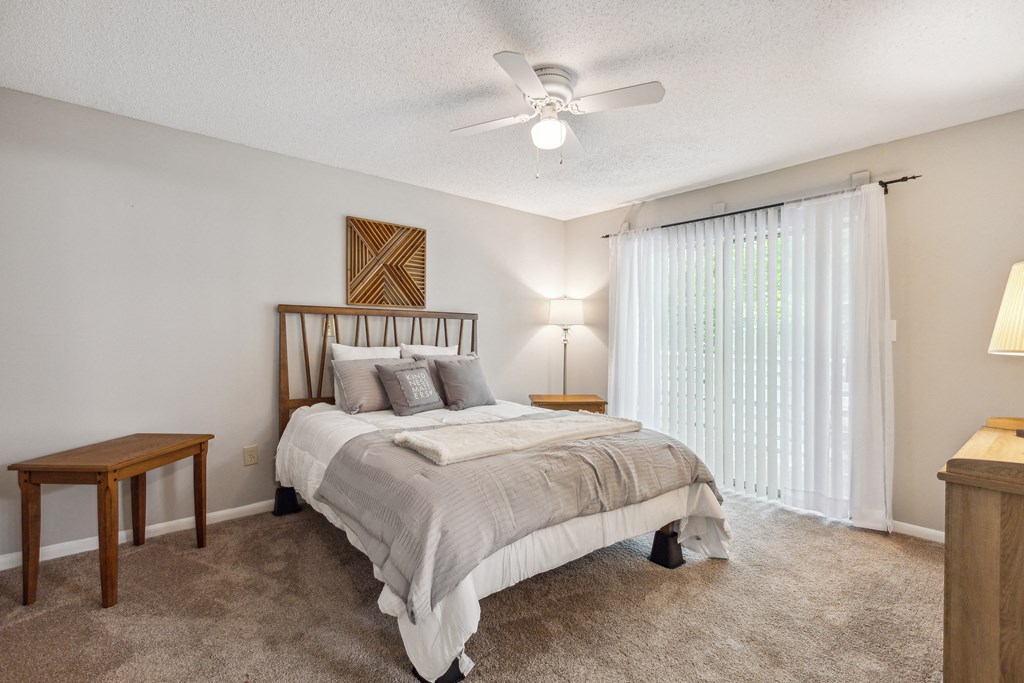 a bedroom with a bed and a ceiling fan