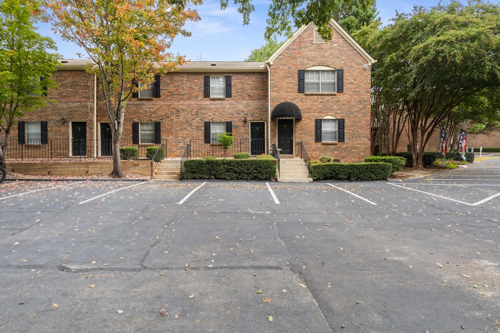an empty parking lot in front of a brick building