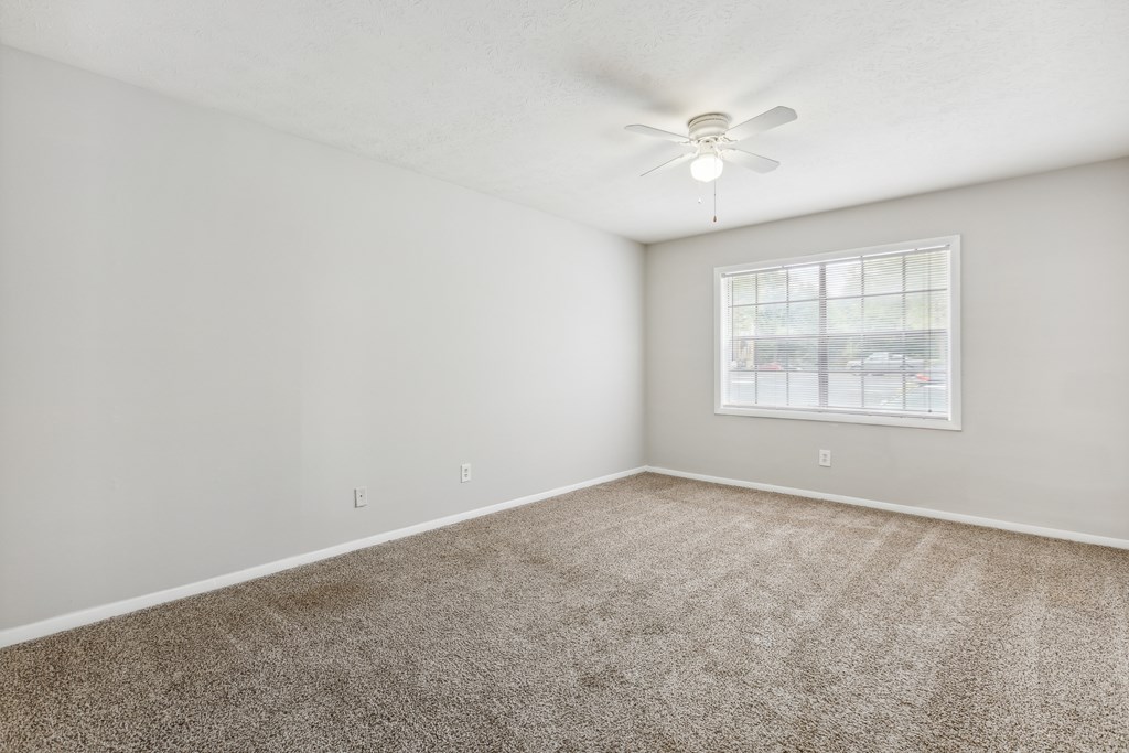 an empty room with carpet and a window