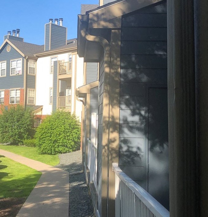 a view of the side of a building with a sidewalk