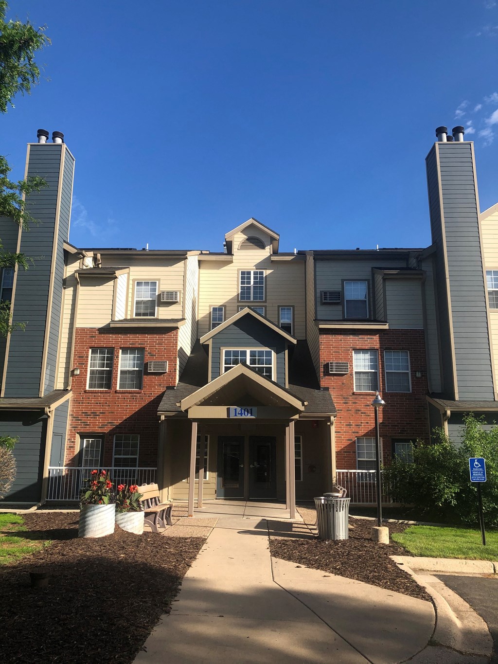an apartment building with a sidewalk in front of it