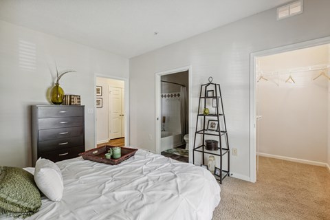 a bedroom with a white bed and a ladder in the closet